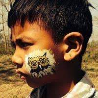 Nepalese child with owl art painted on face. 